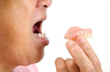 person that is putting in an upper denture