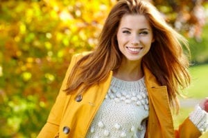 beautiful woman standing outside smiling on a fall day